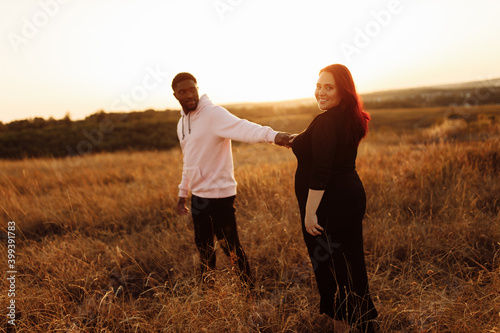 Wonderful couple walking at the field, attractive husband holding hands adorable wife, overjoyed woman smiling, happy family spend time together, weekends outdoors concept