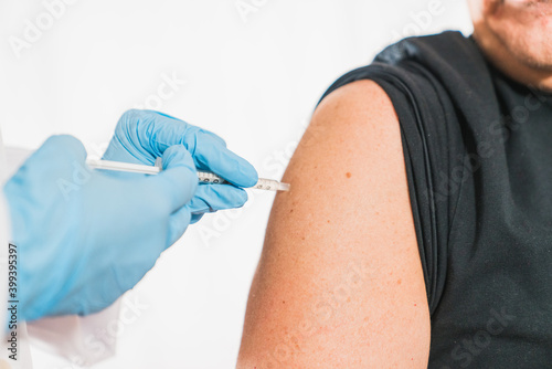 Covid vaccine. Doctor performs a vaccination on the patient's shoulder. Physician vaccinating a patient's shoulder. Influenza vaccination. Injection in the Arm. Injecting the coronavirus. Covid-19