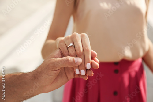 Lovely couple with beautiful ring after engagement outdoors, closeup