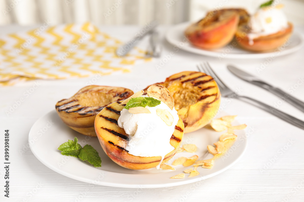 Delicious grilled peaches with ice cream served on white wooden table Delicious grilled peaches with ice cream served on white wooden table