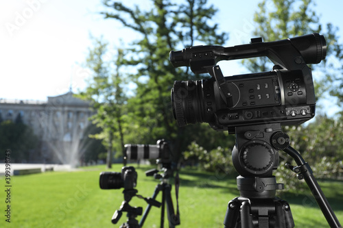 Modern video cameras in park. Professional media equipment