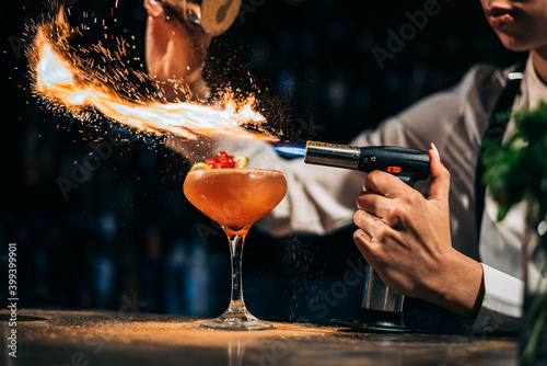 Bartender spilling and burning spices over cocktail