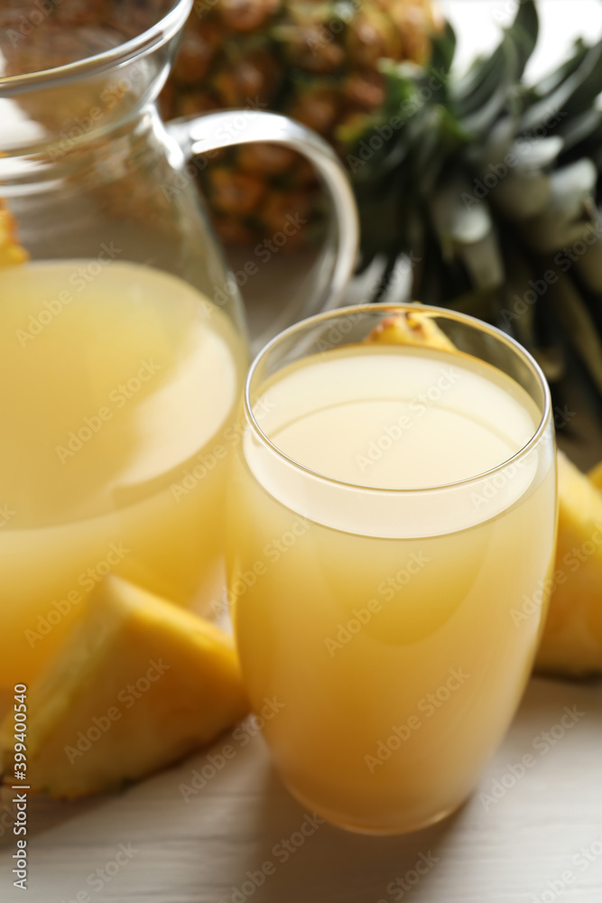 Delicious fresh pineapple juice on white wooden table, closeup Delicious fresh pineapple juice on white wooden table, closeup