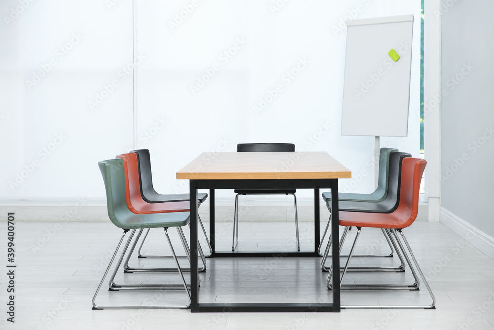 Conference room interior with wooden table and flipchart Conference room interior with wooden table and flipchart