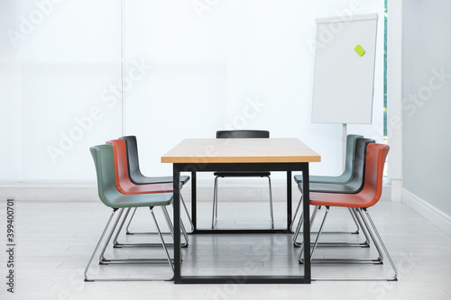 Conference room interior with wooden table and flipchart © New Africa