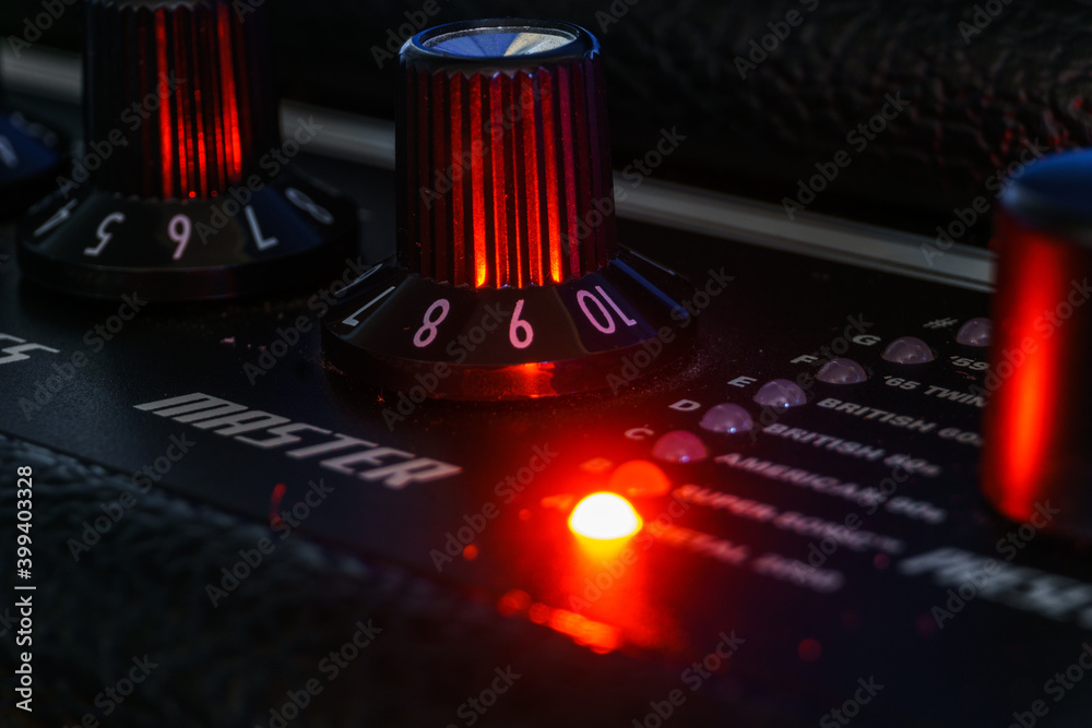 Detail of an amplifier for electric guitar with red lights - obrazy, fototapety, plakaty 