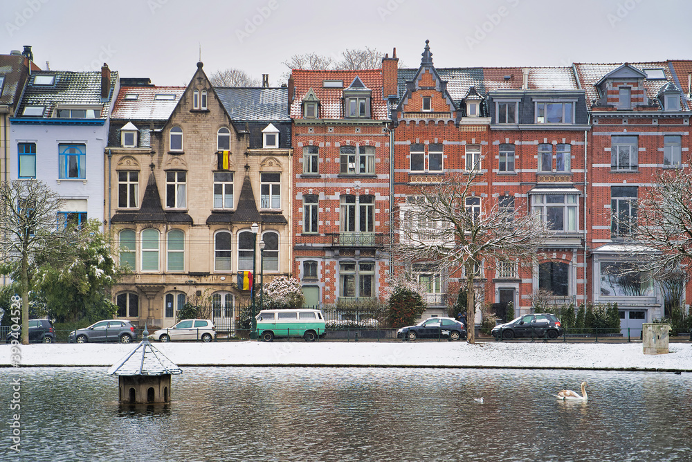 Winter Brussels, snow-covered houses. City landscape with lake in winter, Belgium