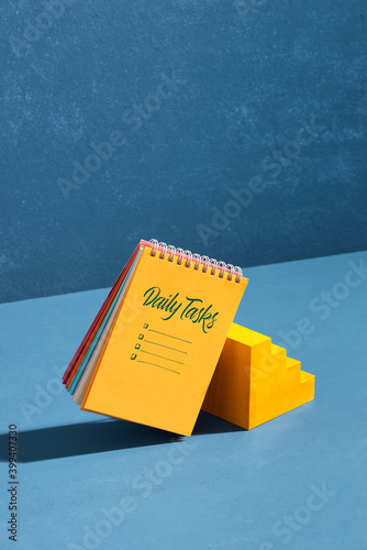 Spiral notebook with handwriting daily tasks near mini stair photo