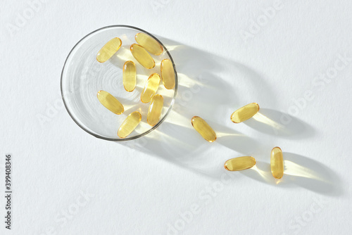 Bunch of omega 3 fish liver oil capsules in small glass bowl