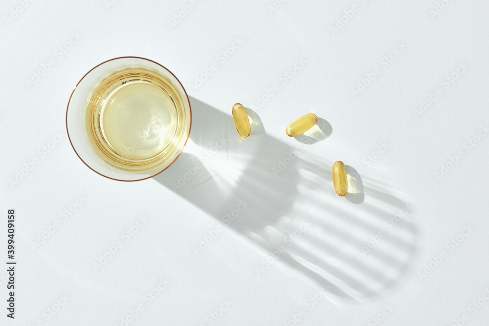Glass of water and fish oil capsule Glass of water and fish oil capsule