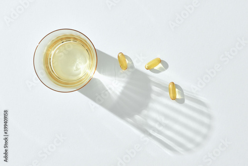 Glass of water and fish oil capsule photo