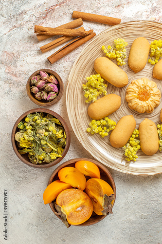 an overhead photo of a plate of cookies and cinnamon sticks and dry flowers and palm