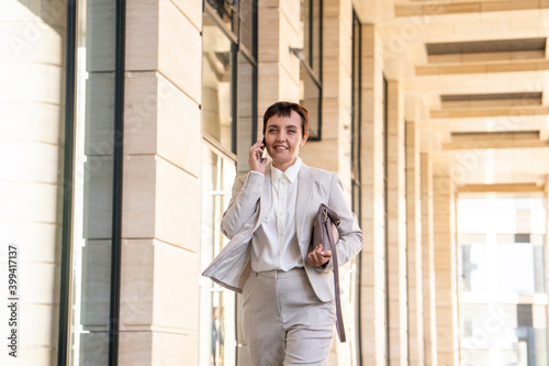 Wallpaper Mural Woman talking on smart phone while walking at office building corridor Torontodigital.ca