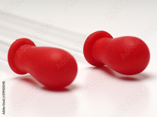 close up shoot of glass pipette with red rubber on a white isolated background