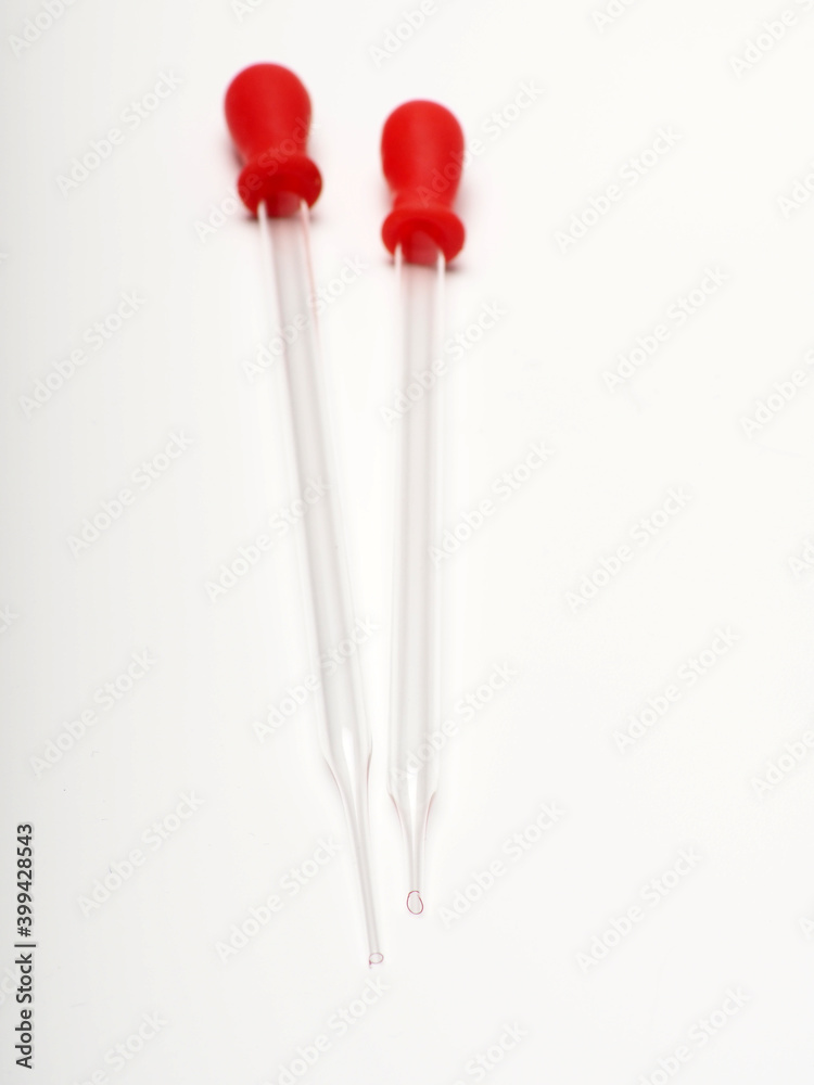 close up shoot of glass pipette with red rubber on a white isolated background