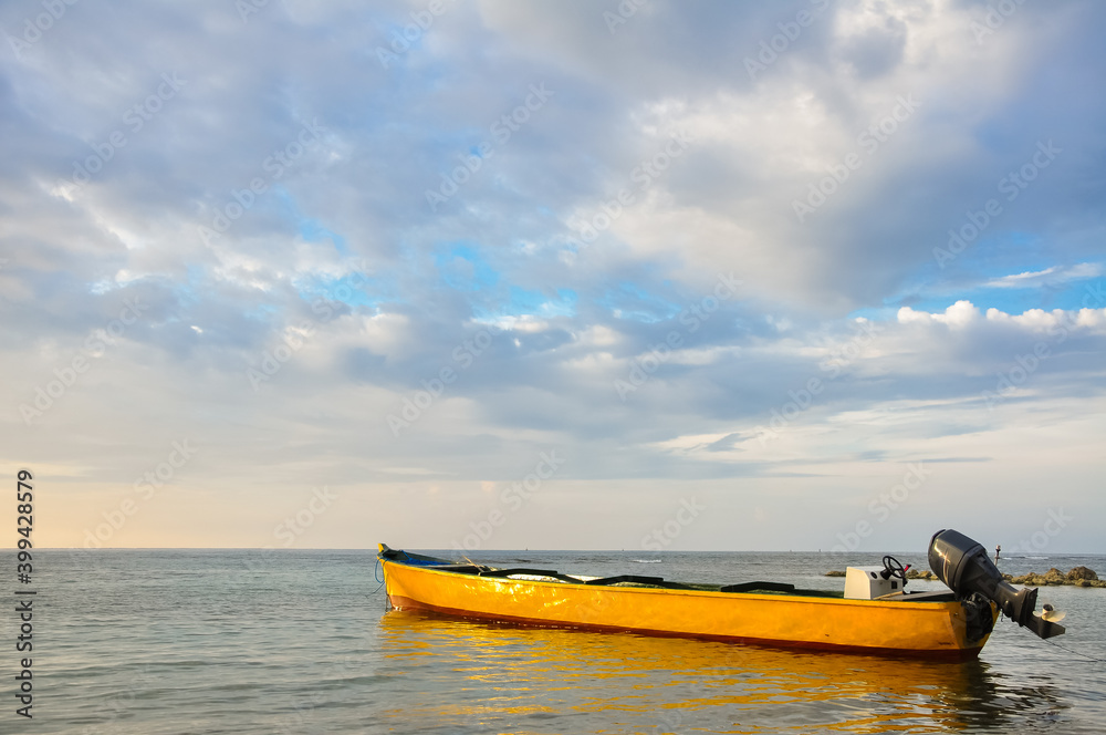 Fototapeta premium yellow boat at sunset on a calm sea