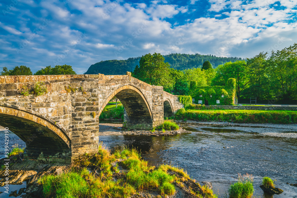 Stone bridge in Llanrwst with old cottage covered with vine leaves. Snowdon, North Wales. UK