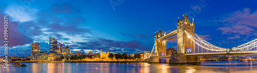 Panorama of Tower Bridge and illuminated skyscrapers in financial district in London  UK