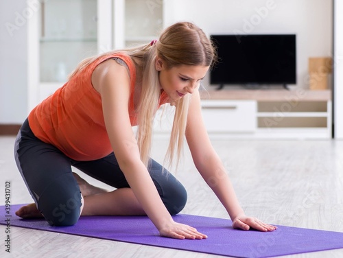 Pregnant woman doing sport exercise at home