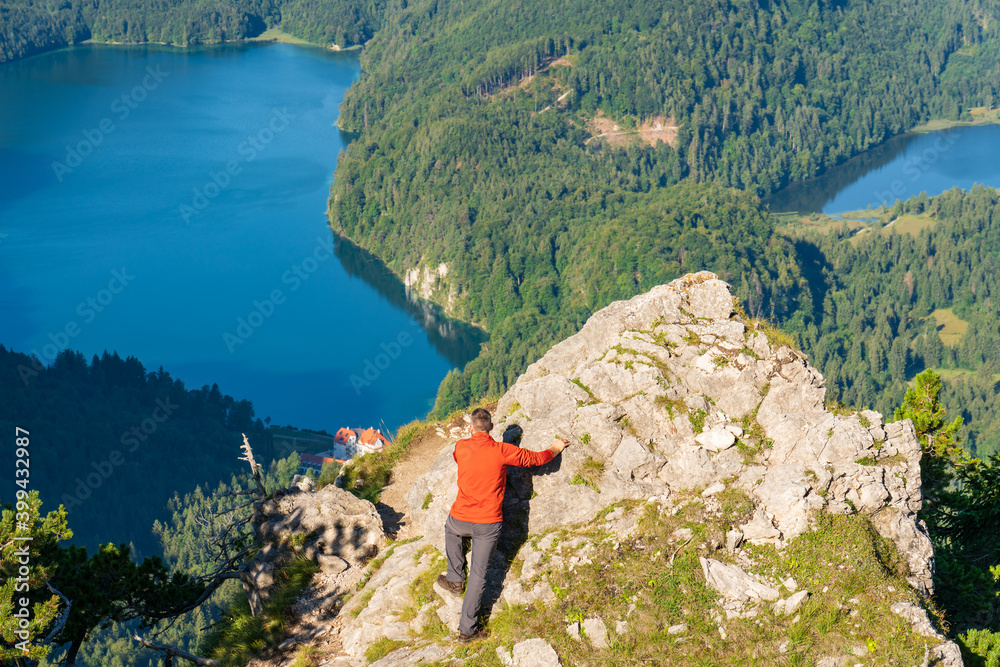 Traveller on top of the mountain overlooking beautiful landscape of Schwangau. Southwest Bavaria. Germany 