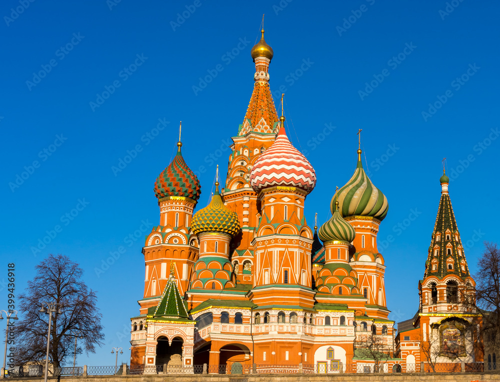 Pokrovsky Cathedral (St. Basil's Cathedral) in the sun against the background of a bright blue sky. View from the Moscow river. Moscow, Russia