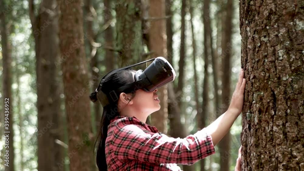 Young asian woman enjoy virtual reality goggles in outdoor park. Modern technology concept. Young asian woman enjoy virtual reality goggles in outdoor park. Modern technology concept.