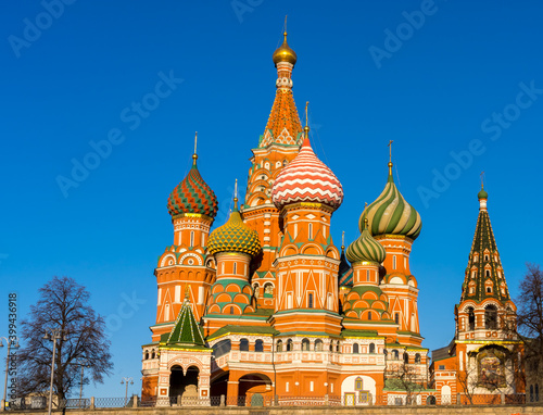 Pokrovsky Cathedral (St. Basil's Cathedral) in the sun against the background of a bright blue sky. View from the Moscow river. Moscow, Russia