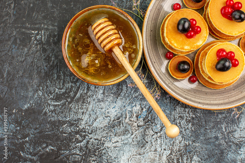 Sweet honey with wooden spoon and fruit pancakes horizontal view stock image