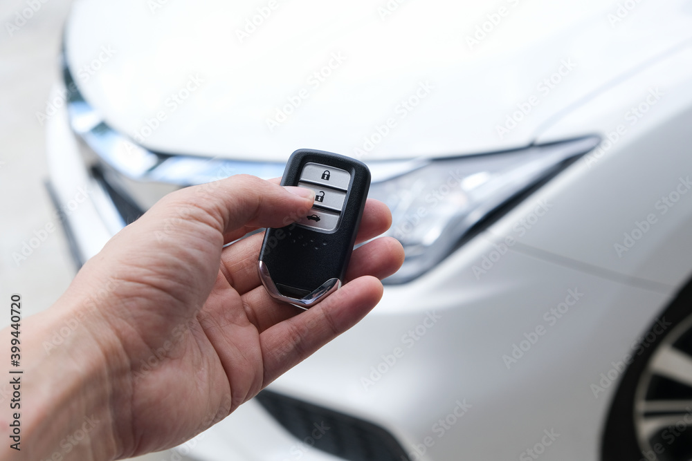 Man hand holding the car remote, he push the remote control to open the car door Man hand holding the car remote, he push the remote control to open the car door