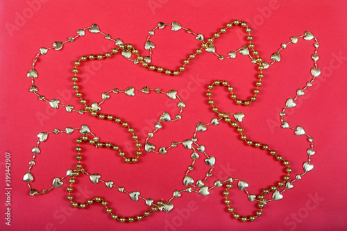 Christmas decor from gold beads on a red background. New Year concept.