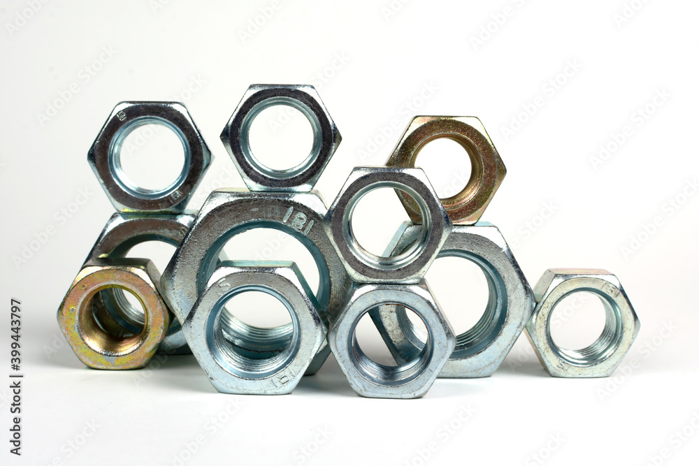 many metal nuts stacked on a white background