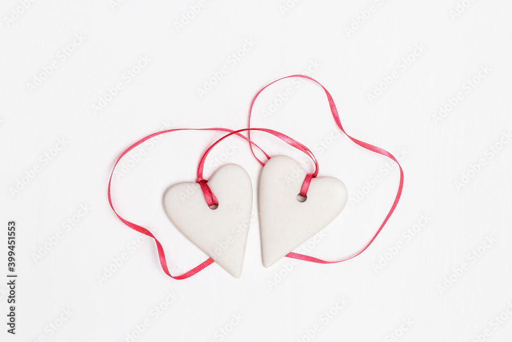 Valentines day composition. Little hearts with pink ribbon on white background. Romantic greeting card about love. Valentines day composition. Little hearts with pink ribbon on white background. Romantic greeting card about love.