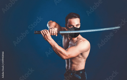 Ninja samurai warrior in mask with naked torso in attack pose with katana sword