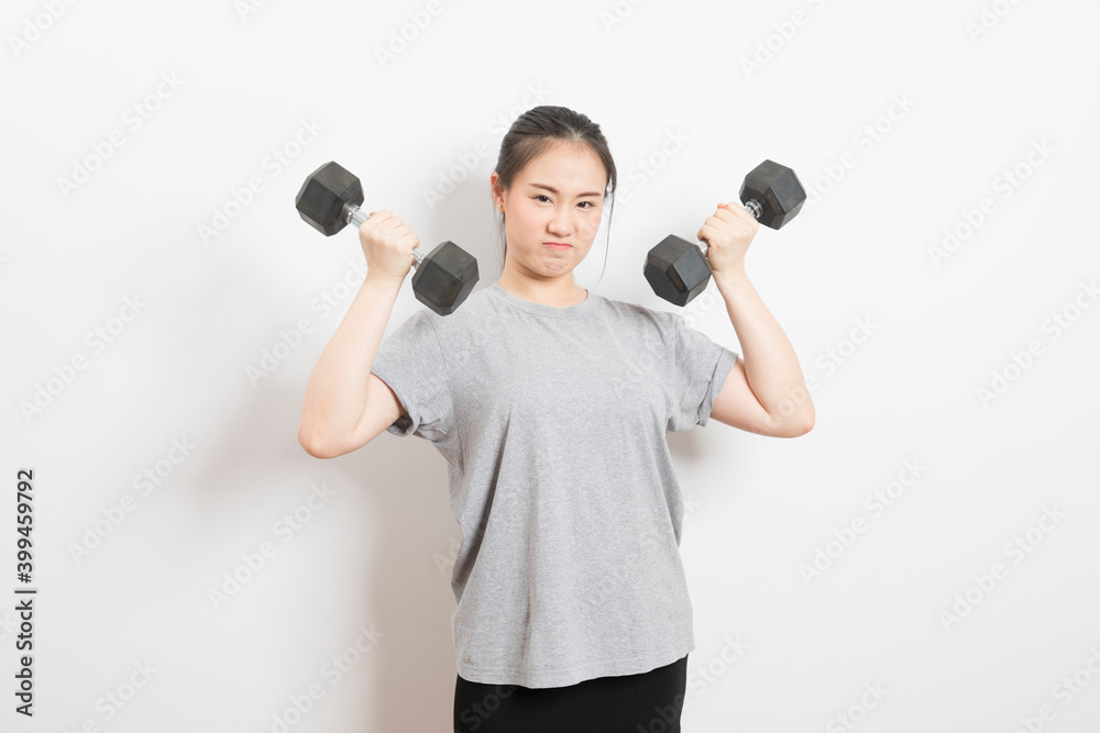 Beautiful young Asian woman lifting dumbbells smiling and energetic isolated over white background. Healthy lifestyle. Beautiful young Asian woman lifting dumbbells smiling and energetic isolated over white background. Healthy lifestyle.