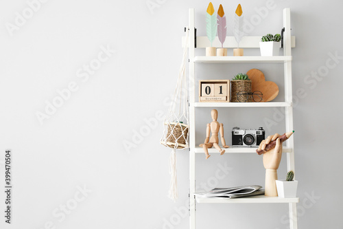 Wooden hand and mannequin with stylish decor on shelving unit in interior of room © Pixel-Shot