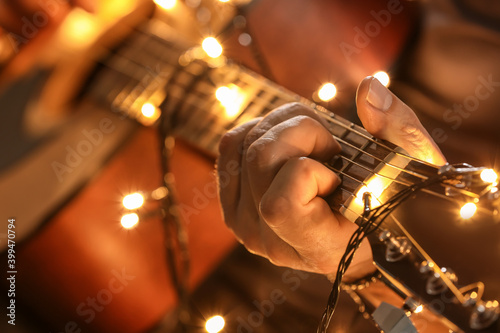 Man playing guitar on Christmas eve, closeup