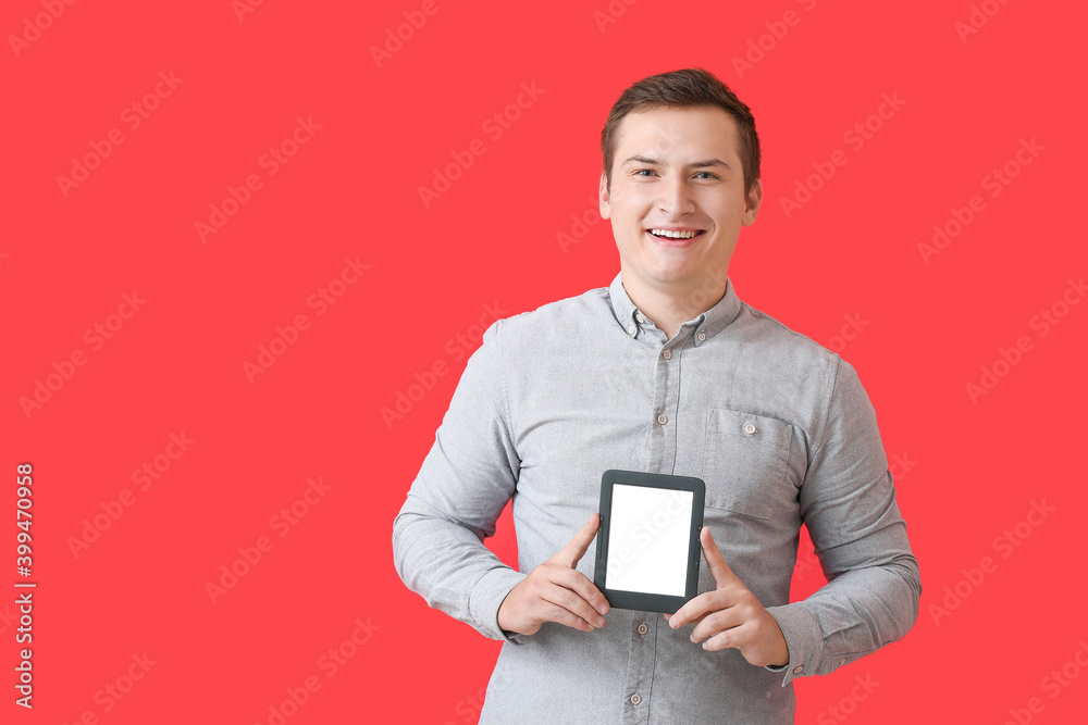 Young man with e-reader on color background Young man with e-reader on color background