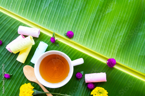 herbal healthy drinks hot honey lemon tea health care for cough sore with dessest, flower marigolds of lifestyle arrangement flat lay style on background banana leaf photo