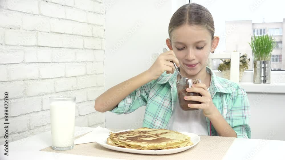Child Preparing Pancakes at Breakfast, Kid Eating Chocolate in Kitchen, Girl Prepares Griddle-Cake at Home Child Preparing Pancakes at Breakfast, Kid Eating Chocolate in Kitchen, Girl Prepares Griddle-Cake at Home