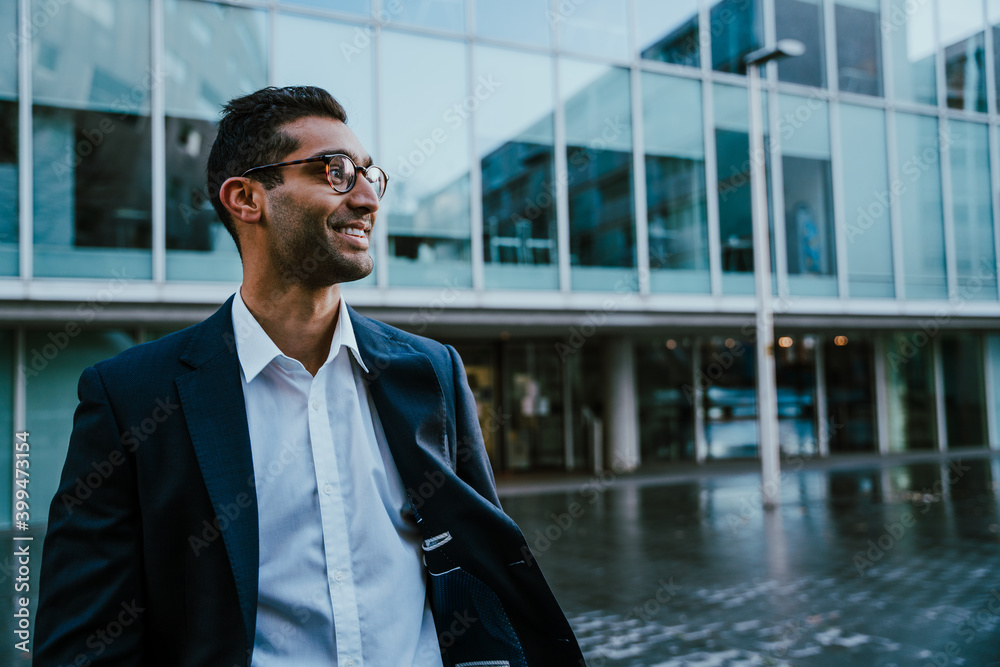 © Prins Productions - Smiling businessman wearing suit feeling happy standing outside banking office