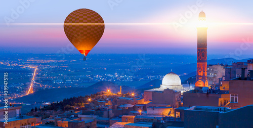 Hot air Balloon flying over Mardin old town - Mardin old town at twilight blue hour - Mardin, Turkey