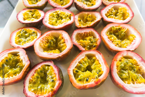 Half cut passion fruits on white plate. Ripe passion fruit isolated on table.