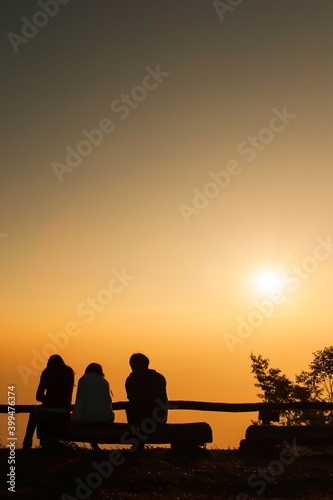 A group of tourists relaxing by viewpoint at sunrise.