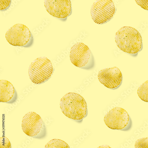 Seamless pattern made from Potato chips on yellow background flat lay. potato snack chips isolated Fast food banner.