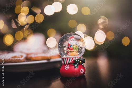 Snow globe in front of Christmas ornaments close up. Snow globe with Santa.