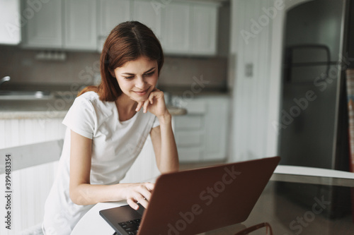 Woman in front of laptop at home communicating internet 