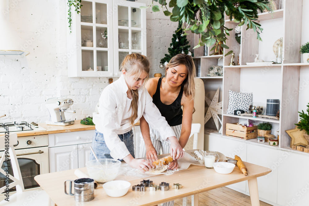 mom and daughter prepare Christmas cookies, new year's pastries, rolling pin, molds, pie mom and daughter prepare Christmas cookies, new year's pastries, rolling pin, molds, pie