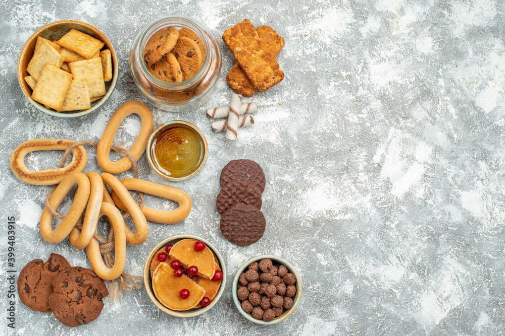 Fototapeta premium Above view of variety of sweeties with fruits cookies biscuits and honey on blue backgrounds