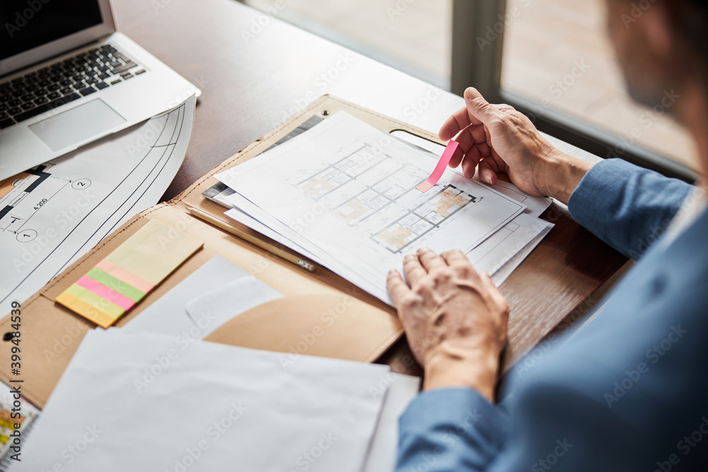Busy office worker closely inspecting paper documentation at office Busy office worker closely inspecting paper documentation at office