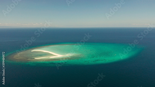 Tropical white island and sandy beach with tourists surrounded by coral reef and blue sea, aerial view. Sandbar Atoll. Island with sand bar and coral reef. Summer and travel vacation concept, Camiguin